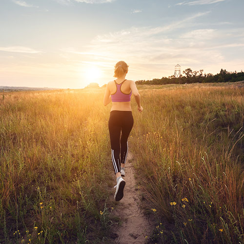 Specialties  Back of woman running in grassy field